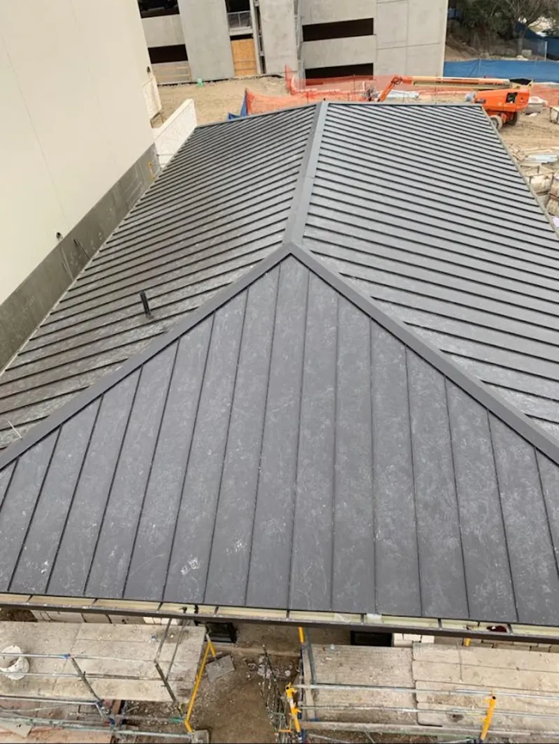 Commercial metal roof construction with crane equipment in Woodridge